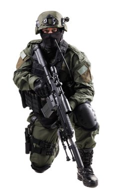 Özel kuvvetler ajanları, bir tüfekle donatılmışken tam teçhizatlı bir teçhizat giyerek, diz çökmüş vaziyette modern askeri profesyonelliğin özünü yakalıyorlar..