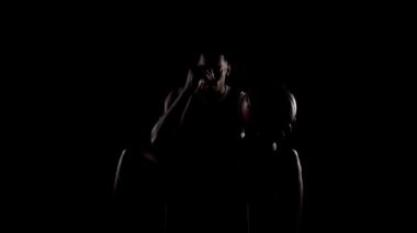 Basketbolcu bankta oturmuş dua ediyor. Siyahi geçmişe karşı dindar Afrikalı Amerikalı sporcu.