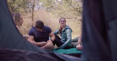 Bir grup arkadaş kamp gezileri sırasında doğal bir ortamda kahve içerken rahatlatıcı bir anın tadını çıkarıyorlar. Kahkahaları ve birlikteliği yakalamak.