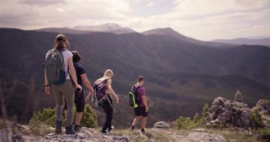 Canlı bir arkadaş grubu, nefes kesen dağlık bir bölgede yürüyüş macerasının tadını çıkarıyor. Yürürken, keşfederken ve sohbet ederken yakalanırlar. Manzaralı manzaralarla çevrili..