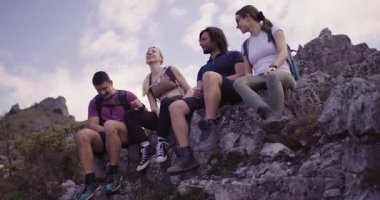 Dört arkadaş bir kayanın üzerinde oturup doğa yürüyüşü sırasında neşeli sohbetler ve neşe dolu kahkahalar atıyorlar. Arkadaşlık ve maceranın mükemmel bir karışımı..