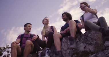 Dört arkadaş bir kayanın üzerinde oturup doğa yürüyüşü sırasında neşeli sohbetler ve neşe dolu kahkahalar atıyorlar. Arkadaşlık ve maceranın mükemmel bir karışımı..