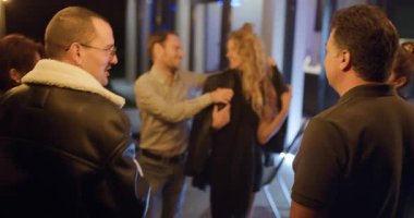 Arkadaşlar bir partide içki içip sohbet etmekten zevk alırlar. Bir erkek ceketini bir kadının etrafına koyar..