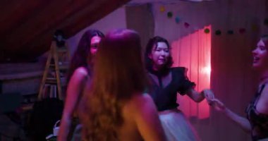 Arkadaşlar mezuniyeti ev partisinde kutluyor. Genç kadınlar mezuniyet partisinde dans edip eğleniyorlar..