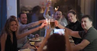 Arkadaşlar bir masanın etrafında toplanıp kadeh kaldırıyorlar. Yemek, içki ve mum ışığında birbirlerine eşlik ederek eğleniyorlar..