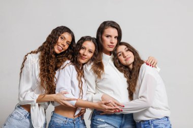 Gündelik giysiler giymiş dört genç yakın etkileşim içinde, arkadaşlığı yansıtıyor, bağ kuruyor ve duyguları canlandırıyor. Grup aktiviteleri ve uyumlu ilişkiler için mükemmel bir kavram..