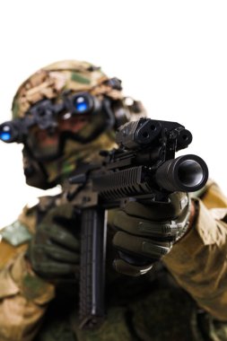 İleri savaş teçhizatı giymiş bir asker elinde tüfekle harekete geçmeye hazır. Yakın plan kompozisyonda hassasiyet, hazırlık ve modern askeri teknoloji vurgulanıyor. Profesyonelliği gösterir ve