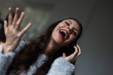 Yüzüne yakın elleri ile gülen neşeli bir kadın, mutluluğu ve güveni yansıtan sıradan bir anda yakalandı..