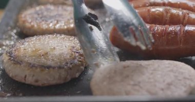 Barbekü biftekli burger ve ızgarada sosis..