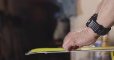 Kayak yapan bir adam. Özel ekipmanlarla çalışan soyut erkek eller. Kayak yüzeyinden fazla balmumu çıkarıyorum. Sinema kamerasıyla kaydedilen videoyu kapat.