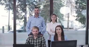 Modern bir ofiste kameraya gülümseyen kendine güvenen bir iş adamının portresi. İş dünyasında takım çalışması ve başarı..