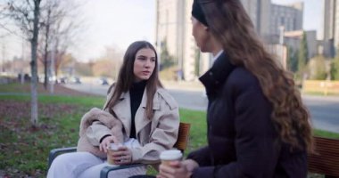 Dışarıda kahve içerken kız arkadaşlar konuşuyor ve gülüyor. Arkadaşlık, iletişim ve insanlar konsepti.