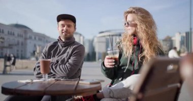 İki arkadaş güzel bir günde açık bir kafede kahve içerken rahatlar ve sohbet ederler..