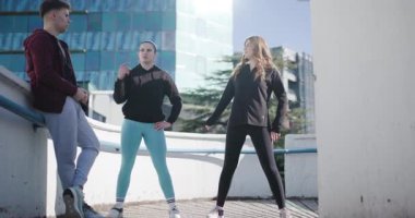 Üç arkadaş, bir erkek ve iki kadın, şehirde bir çatı katında ısınıp esniyorlar. Kentsel bir ortamda spor ve arkadaşlık.