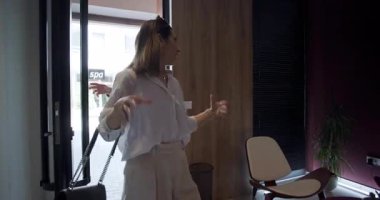 İki arkadaş buluşacakları için heyecanlı bir şekilde birbirlerini bir girişte selamlıyorlar. Modern ortam, doğal ışık ve dostça sohbet için mükemmel bir ortam yaratıyor..