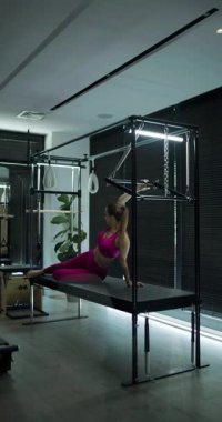 Katılımcılar zarif ve çağdaş bir stüdyoda zorlu bir pilates seansına katılıyorlar..