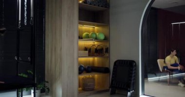 İki birey, bitkiler ve çağdaş mobilyalarla çevrili gösterişli bir ofis alanında takım çalışmasını ve işbirliğini vurgulayan bir tartışmaya giriştiler..