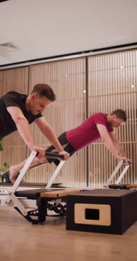 Gösterişli bir spor salonunda, iki kişi denge ve fiziksel dayanıklılıklarını arttırmak için spor aletleri kullanarak güçlü bir antrenman yapıyorlar. Odaklanma tekniği ve şekli üzerine..