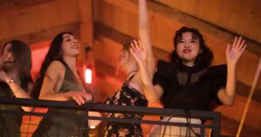 Dört genç bayan arkadaş bir partide ya da kulüpte dans edip eğleniyorlar. Balkondan ya da asma kattan kutluyorlar. Müziğe el sallıyorlar..