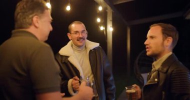 Üç arkadaş bir partide birlikte bira içmekten, gülmekten, içki içmekten ve terasta konuşmaktan zevk alıyorlar. Sıcak sicim ışıkları samimi bir ortam yaratır..