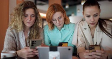 Çağdaş bir iş ortamında akıllı telefonlarındaki bilgileri incelerken üç kadın bir tartışmaya girişiyor. Odaklanıyorlar ve görüşlerini paylaşıyorlar..