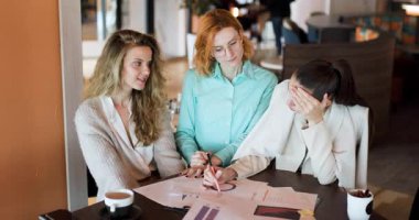 Üç kararlı kadın şık bir kafede verimli bir tartışmaya girişiyor, iş planları için görüşlerini paylaştıkları çizelge ve notları gözden geçiriyorlar. Yoldaşlıkları parlıyor..