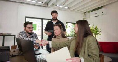 Ofisteki bir projede iş birliği yapan bir iş ekibi. Belgeleri gözden geçirir, fikirleri tartışır, takım çalışması ve üretkenlik gösterirler..