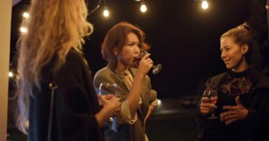 Üç farklı arkadaş, gece partisinde festival ışıkları altında içki içip sohbet etmekten hoşlanırlar. Kahkaha, bağlantı ve kutlama havayı dolduruyor..