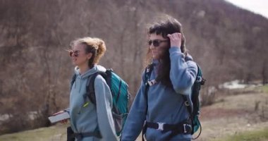 Doğa yürüyüşü yapan iki bayan arkadaş. Yol tarifini kontrol etmek ve yürüyüşlerini yapmak için telefonlarına bakıyorlar..