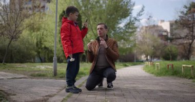 Bir baba ve oğlu şehir parkında birlikte vakit geçirip doğayı keşfediyorlar. Babası diz çökerken çocuk elinde bir kamera tutuyor. Etrafı incelikle seyrediyor..