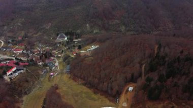 Mavrovo National Park in North Macedonia during autumn. Drone view of ski resort with chalets. Resort hotels and forested mountains in distance.