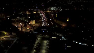 Aerial view of Skopje, North Macedonia at night. Cars driving on the highway, city lights, and the Kale Fortress.