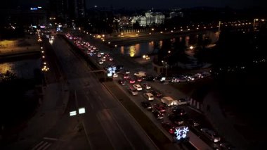 Busy Evening Rush Hour Traffic Jam in City Center with Christmas Decorations and Lights by the River at Dusk