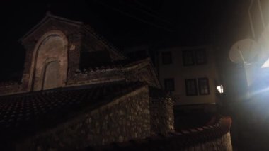 Church of St. Demetrius in the old town of Ohrid, North Macedonia at night. The Church is surrounded by traditional houses. The video evokes a sense of history and serenity.
