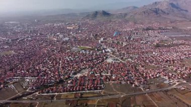 Person paragliding over eastern european town. Aerial drone video of Prilep in North Macedonia.