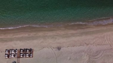 Kafe ya da restoran sandalyeleri ve deniz kenarındaki ahşap bir platformda masalar. Gökyüzü boş sahil manzarası.