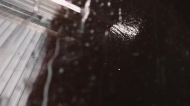 Observe the unique reflections and textures forming on the surface while washing a car at an automatic car wash. It reveals interesting effects created by water and light.