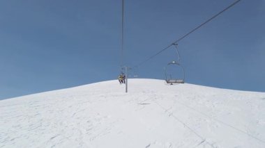 Enjoy the breathtaking views as the ski lift ascends towards the snowy summit, surrounded by clear blue skies and the thrill of a winter wonderland. Feel the excitement of winter sports.
