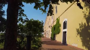 Wander through the scenic paths of Novi Sad, enjoying the picturesque views near Petrovaradin Fortress. Experience the warm sun and lush greenery in this beautiful setting.