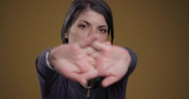 A young woman in a casual outfit stretching her hands with a blurred background