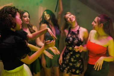 A vibrant gathering of friends sharing joyful moments, dancing, and celebrating in a colorful and dynamic environment with smiles and energy.