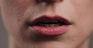 Detailed close-up of a young adults lips, highlighting natural skin texture, soft smile, and neutral expression in a high-resolution image.