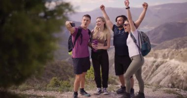 Dağlarda yürüyüş yapan dört arkadaştan oluşan bir grup. Eğleniyorlar, selfie çekiyorlar, el ele tutuşuyorlar, doğadaki neşeli bir anı yakalıyorlar..