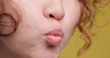 Detailed close-up of a young womans face showcasing a playful pucker of her lips, highlighting unique facial expressions and subtle skin textures.