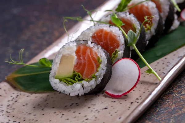 スパイス付きのカラフルなプレートで提供される美味しい寿司ロール ストック画像