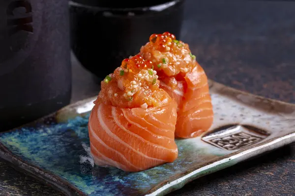 Lachs Sushi Japanisches Essen Auf Schwarzem Schiefergrund lizenzfreie Stockbilder