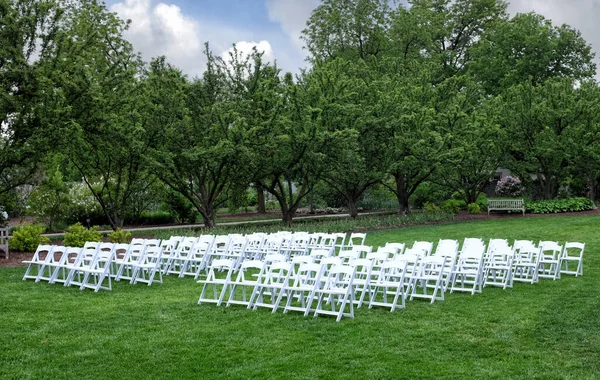 stock image Rows of White chairs set up on a lawn for an outdoor event or wedding.