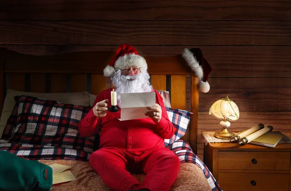 Santa Claus Sitting His Bed Wearing Red Long Johns Holding — Stock Photo, Image