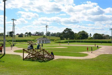 DYERSVILLE, IOWA - 20 Ağustos 2015: Field of Dreams film seti. Ebeveynler ve çocuklar, Kevin Costner 'ın oynadığı 1989 yapımı filmin setinde, taraftarlar tribünde otururken,.