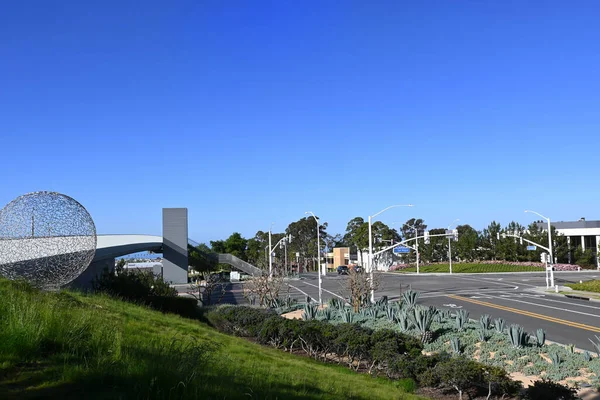 カリフォルニア州ニューポートビーチ 2023年4月22日 歩行者用橋はサンミゲルドライブを愛するアボカド アヴェ市民センター公園の2つの半分を背景にオフィスビルと接続しています — ストック写真